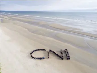  ??  ?? Students gathered on the beach to form the initials of the school.