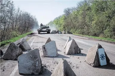  ?? FOTO: AFP ?? Un tanque ucraniano atraviesa obstáculos en una carretera cerca de Sloviansk, en el este de Ucrania. El ejército ucraniano recibirá ayuda de armamento y dinero de Estados Unidos y sus aliados.
