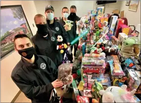  ?? SUBMITTED PHOTO ?? Who said only kids play with toys? Some Clinton Township firefighte­rs proudly stand guard over toys donated by residents that will be given to the Toys For Tots campaign.