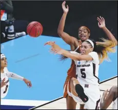  ?? Associated Press ?? DOMINATE — South Carolina forward Victaria Saxton (5) and Texas forward Charli Collier, center back, battle for control of a rebound during the first half of a game in the Elite Eight round of the women’s NCAA tournament at the Alamodome in San Antonio on Tuesday.