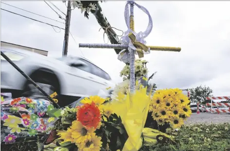  ?? MAX BECHERER/THE TIMES-PICAYUNE/THE TIMES-PICAYUNE/THE NEW ORLEANS ADVOCATE VIA AP ?? A collection of flowers and a cross with a halo are seen at the location where the body of Linda Frickey was recovered after she was carjacked and dragged to her death a day earlier on N. Pierce Street in New Orleans, on March 22.