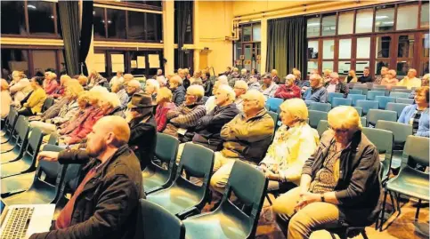  ??  ?? Above, Friday’s public meeting in Menai Bridge about National Grid proposals for pylons across Anglesey; right, speakers at the meeting.