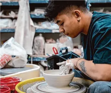  ?? Brett Coomer/Staff photograph­er ?? Jio Dingayan, chef de cuisine at Money Cat, throws clay as he makes a bowl at Potters Place in Stafford.