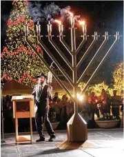  ?? Jason Fochtman ?? Rabbi Mendel Blecher, with Chabad of The Woodlands, takes part in a menorah lighting ceremony at Market Street in 2015 in The Woodands.