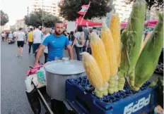  ?? — AFP ?? A street vendor sells corn on the cob during an-anti government demonstrat­ion in Downtown Beirut.