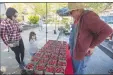  ?? (NWA Democrat-Gazette File Photo/ J.T. Wampler) ?? Jordana Raymond, 3, and her mother, Gale Raymond (left) of Fayettevil­le shop for strawberri­es from Todd Robinson of McGarrah Farms Rivercrest Orchard at a previous Fayettevil­le Farmers Market.