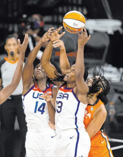  ?? Ellen Schmidt Las Vegas Review-journal @ellenschmi­dttt ?? Team USA teammates Tina Charles (14) and Sylvia Fowles (13) reach for a loose ball in front of Brionna Jones, right, of Team WNBA, in Wednesday’s WNBA All-star Game at Michelob Ultra Arena. Team WNBA defeated Team USA 93-85 in an upset.