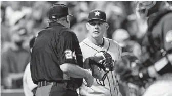  ?? David Zalubowski / Associated Press ?? Astros manager AJ Hinch, center, mildly protests a replay ruling that cost Alex Bregman a triple due to fan interferen­ce in the sixth inning Wednesday night.