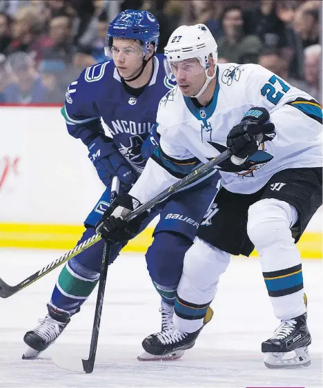  ?? GERRY KAHRMANN ?? Canucks right wing Nikolay Goldobin, seen crossing sticks with San Jose Sharks winger Joonas Donskoi this month, says he didn’t know fellow Russian Alex Burmistrov would leave the NHL.