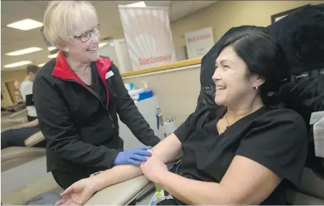  ?? DAX MELMER ?? Mary Parlardg a registered nurse with Canadian Blood Services finishes taking blood from Shelley Limoges on Monday.