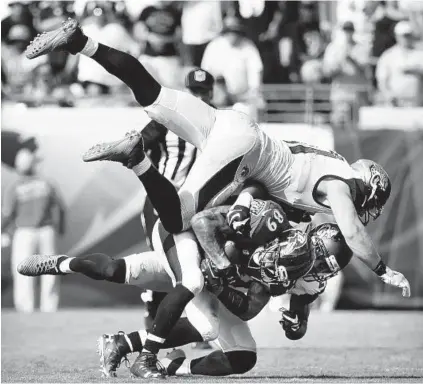  ?? KENNETH K. LAM/BALTIMORE SUN PHOTOS ?? Ravens wide receiver Steve Smith Sr. (89) gains 5 yards on a fourth-and-2 catch before being tackled by the Jaguars’ Paul Posluszny, top, and Dwayne Gratz in the fourth quarter. The reception was part of the drive that set up Justin Tucker’s go-ahead...