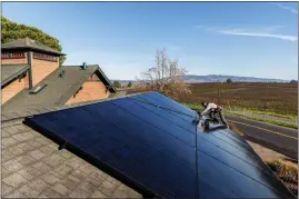  ?? RACHEL BUJALSKI — THE NEW YORK TIMES ?? An Amy's Roofing & Solar employee installs panels on a house in Sebastopol on Jan. 5. A new policy in California has lowered the value of credits for some solar homeowners.