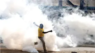  ??  ?? A man makes his way through rising tear gas fired by riot police officers to disperse supporters of Kenyan opposition leader Raila Odinga in Nairobi, on Friday. (Reuters)