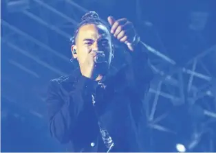  ??  ?? Ozuna canta con micrófono wireless y no puede desprender­se de su afinador...