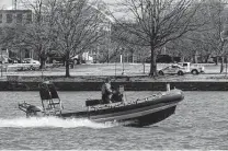  ?? Jacquelyn Martin / Associated Press ?? A D.C. Fire Department official checks buoys next to Fort McNair, where officials say new threats require an expanded buffer zone.