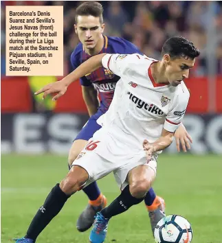  ??  ?? Barcelona's Denis Suarez and Sevilla's Jesus Navas (front) challenge for the ball during their La Liga match at the Sanchez Pizjuan stadium, in Seville, Spain, on Saturday.