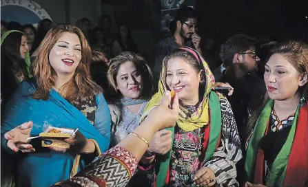  ?? SHAKIL ADIL THE ASSOCIATED PRESS ?? Supporters of politician Imran Khan, chief of the Pakistan Tehreek-e-Insaf party, offer sweets to celebrate victory in Karachi, Pakistan on Thursday.