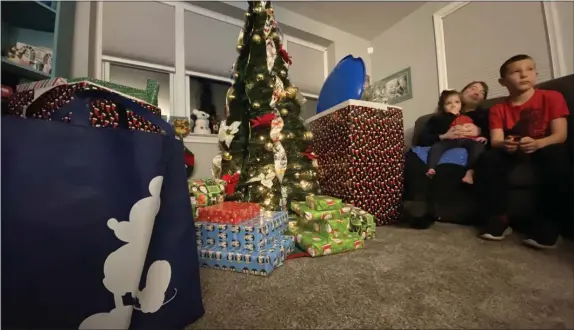  ?? KEVIN TUSTIN - MEDIANEWS GROUP ?? Just a portion of the bounty of donated gifts that filled the Malinowski’s living room Monday night as the children pile up on the couch.