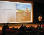  ?? ?? Quest Diagnostic­s pilot Zach Warren reads to kindergart­ners at Willow Creek Elementary School Thursday during an assembly about the importance of reading.