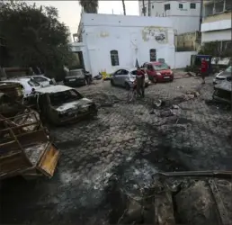  ?? Abed Khaled/Associated Press ?? Palestinia­ns check the place of the explosion at al-Ahli hospital, in Gaza City.