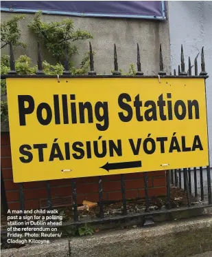  ??  ?? A man and child walk past a sign for a polling station in Dublin ahead of the referendum on Friday. Photo: Reuters/ Clodagh Kilcoyne