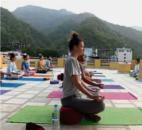  ?? — AFP ?? Inner peace: People practising yoga on a terrace at the Anand Prakash yoga ashram in Rishikesh in Uttarakhan­d state in India.