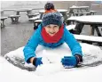  ??  ?? Thomas Waugh, seven, enjoys the first snow of October in the Scottish Highlands