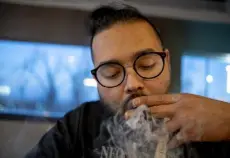  ?? ?? David Medina smokes a joint at JAD’S Mile High Smoke on April 29.