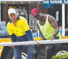  ??  ?? CLOSE WATCH: Teryson Kulka and Wilton Brim set up for today’s Chinese New Year event in Grafton Street.