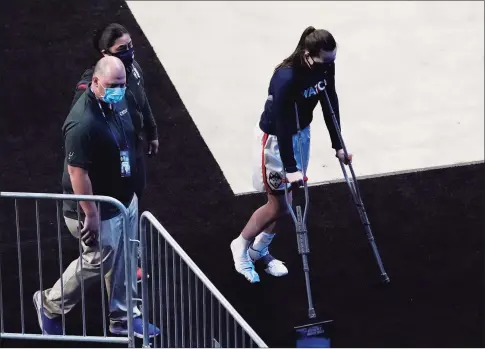  ?? Eric Gay / Associated Press ?? UConn guard Nika Muhl leaves the arena floor on crutches after an injury on Sunday night. It is unclear is she will be able to play in Tuesday’s NCAA Tournament game against Syracuse.