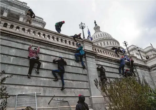 ?? Michael Robinson Chavez / Washington Post ?? Supporters of President Donald Trump climb the west wall of the the U.S. Capitol on Wednesday in Washington, D.C.