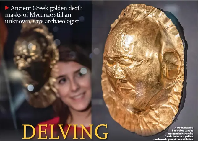  ?? Photo: AFP ?? A woman at the Badisches Landes museum in Karlsruhe Castle looks at a golden tomb mask, part of the exhibition Mycenae - The Legendary World of Agamemnon, in Germany in 2018.