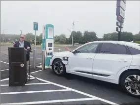 ?? Abigail Brone / Hearst Connecticu­t Media ?? The state's first universal electric-car-charging stations are installed at the southbound I-95 service plaza in Madison. DOT Commission­er Joe Giulietti speaks about the station's benefits on Friday.