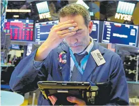  ?? Picture / AP ?? A New York Stock Exchange trader counts up the losses.