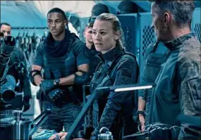  ??  ?? Chris Pratt, above, and at left, Keith Powers, background left, and Yvonne Strahovski, center, in "The Tomorrow War."