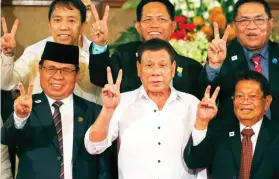  ?? AP FOTO ?? DRAFT LAW. President Rodrigo Duterte, center; Al-Hajj Murad, left, chair of Moro Islamic Liberation Front (MILF); Ghazali Jaafar, MILF vice-chair; and other leaders flash v-signs for peace during a ceremony for the submission of the draft of the...