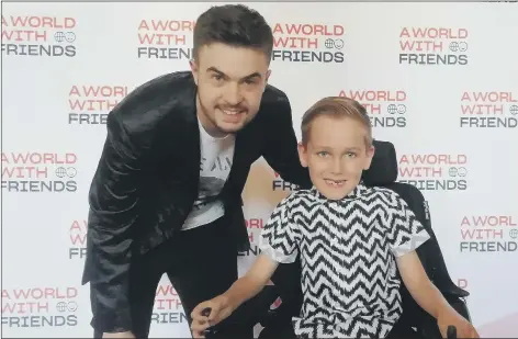  ?? Picture: David George ?? VIRTUAL WORLD Lewis Hine, left, with seven-year-old Archie Kambanis, from Northampto­n, at the annual A World With Friends prom at Portsmouth Guildhall