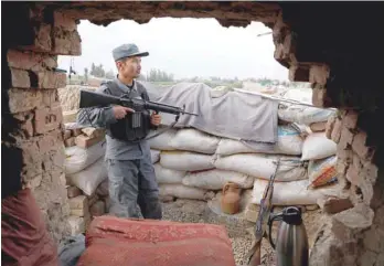  ?? — Reuters ?? An Afghan policeman keeps watch at the check post on the outskirts of Kabul on Tuesday.