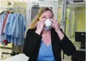  ?? Reuters ?? Dr. Nicole McCullough, a safety expert at 3M, demonstrat­es the correct way to put on an
N95 respirator­y mask. The mask, below, is the subject of a row between the company and US President Donald Trump.