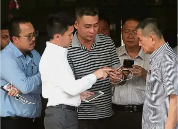  ??  ?? Show of support: Swee Bok (centre) with Chong (second from left) and Tan (right) outside the Penang Hospital mortuary.