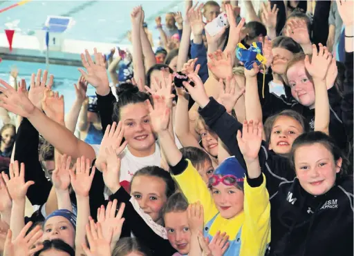  ??  ?? ●●Holly is welcomed home at Life Leisure by her fellow Stockport Metro swimmers