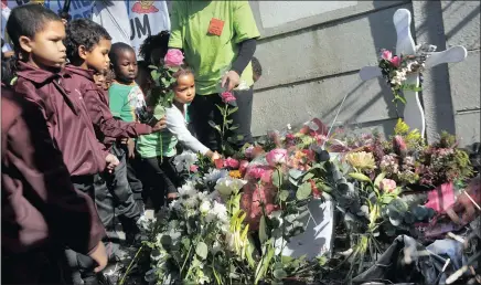  ?? PICTURE: ARMAND HOUGH ?? Children lay down flowers at the site where the body of Courtney Pieters was found. Community Safety MEC Dan Plato, children and community members from Eerste River visited the crime scene.