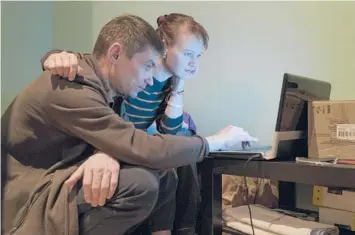  ?? EMILE DUCKE/THE NEW YORK TIMES ?? Aleksandr Dobriyanik, left, and his partner, Olga Ageyeva, who fled the crackdown in Belarus, search online for a place to rent on Nov. 19 in Vilnius, Lithuania. Belarusian­s seeking asylum in Lithuania are processed quickly.