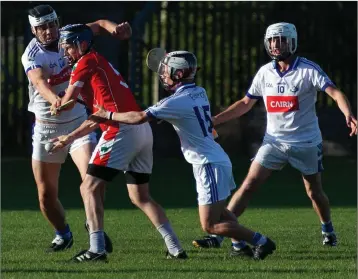  ??  ?? Glenealy’s Gary Byrne hand passes out of a tight situation.