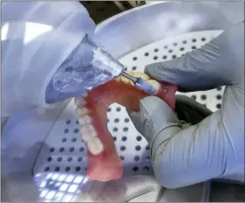  ?? BRETT COOMER/HOUSTON CHRONICLE VIA AP, FILE ?? In this June 13, 2019, file photo, a dentist smooths out the edges of new 3D printed dentures in Huntsville, Texas.