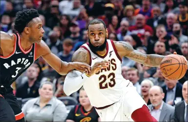  ?? DAVID RICHARD / USA TODAY SPORTS ?? Cleveland Cavaliers forward LeBron James drives downcourt as Toronto Raptors guard DeMar DeRozan defends in the fourth quarter of Tuesday’s NBA clash at Quicken Loans Arena in Cleveland, Ohio. The Cavs won 112-106.