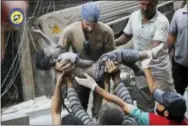  ?? SYRIAN CIVIL DEFENSE WHITE HELMETS VIA AP ?? This Tuesday photo provided by the Syrian Civil Defense group known as the White Helmets shows a Civil Defense worker carrying the body of a child after airstrikes hit alShaar neighborho­od in Aleppo, Syria.