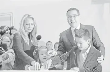  ??  ?? Ponta and his wife Daciana Sarbu cast their votes next to their children at a polling station in Bucharest. — Reuters photo