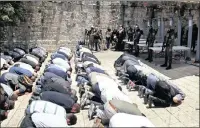  ?? PICTURE: AP ?? Israeli police stand guard as Muslim men pray outside the Al- Aqsa Mosque compound in Jerusalem yesterday.