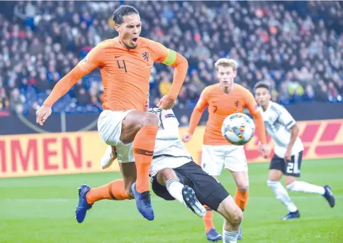  ?? — AFP photo ?? Netherland­s' captain Virgil van Dijk (L) equalised in the 91st minute to grab a point in Monday's 2-2 draw against Germany, which was enough to put the Dutch into the Nations League semi-finals at the expense of world champions France.
